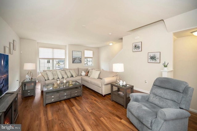 living room featuring dark wood-type flooring and baseboards