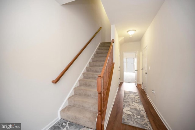 stairway featuring wood finished floors and baseboards