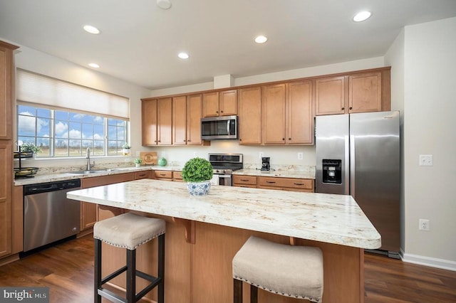 kitchen with dark wood finished floors, recessed lighting, stainless steel appliances, and light stone countertops