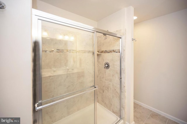 full bath featuring baseboards and a shower stall