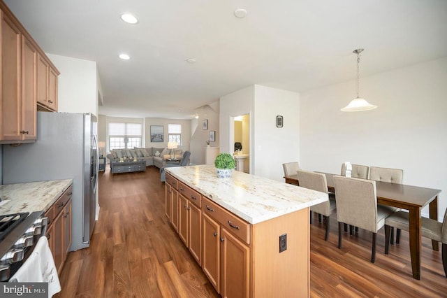 kitchen featuring light stone counters, dark wood-style floors, open floor plan, and a center island