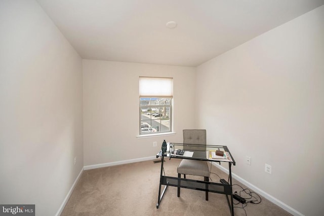 office featuring baseboards and light colored carpet