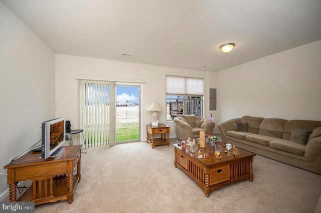 living room with electric panel, visible vents, and light carpet