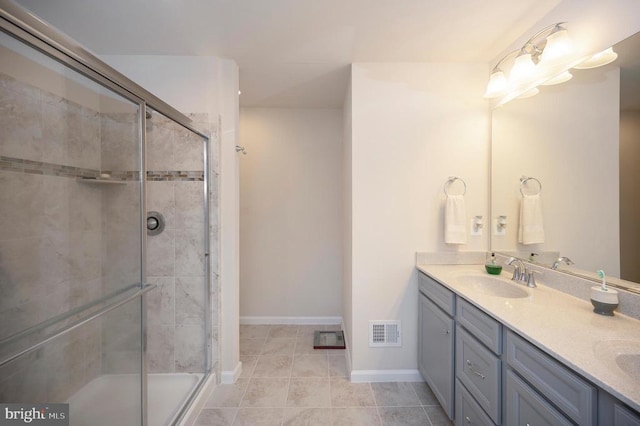 full bath featuring double vanity, visible vents, a shower stall, and a sink