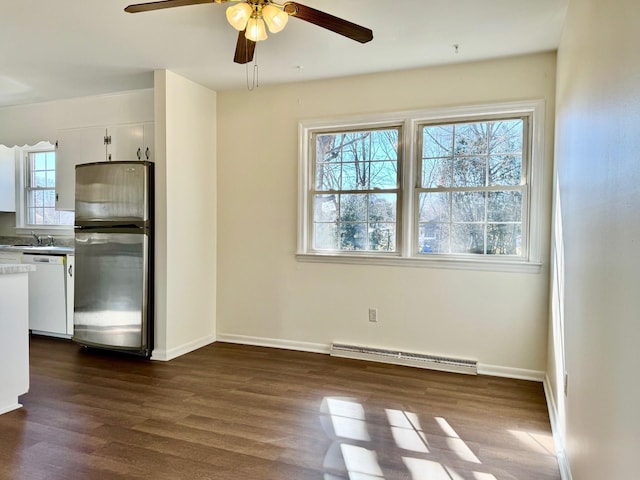 unfurnished dining area featuring sink, a baseboard radiator, dark hardwood / wood-style floors, and ceiling fan