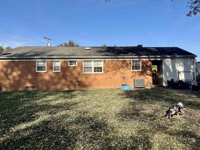 back of house featuring cooling unit and a lawn