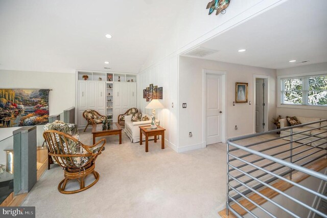 sitting room featuring lofted ceiling and light colored carpet