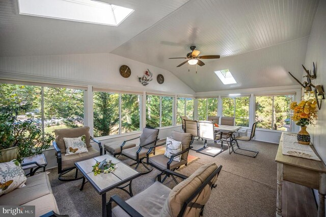 sunroom / solarium featuring lofted ceiling with skylight and ceiling fan