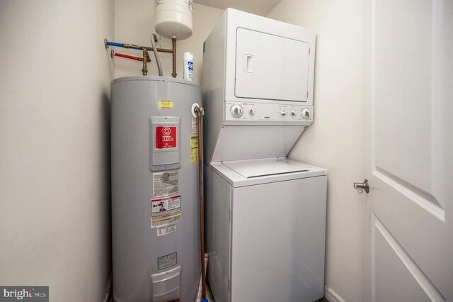 laundry area with water heater and stacked washer and dryer