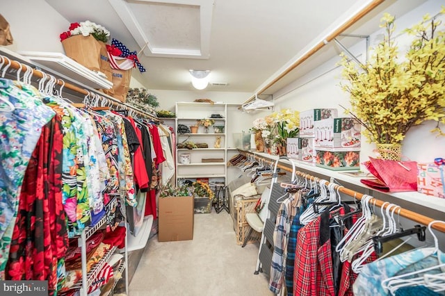 walk in closet featuring light colored carpet