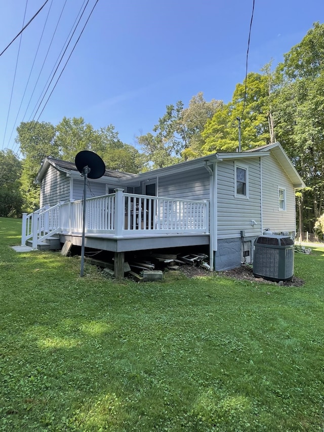 back of house featuring a yard, a deck, and central air condition unit