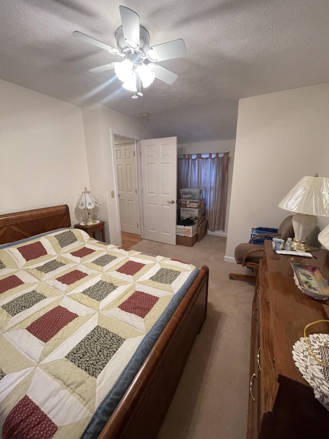 bedroom featuring ceiling fan, a textured ceiling, and carpet