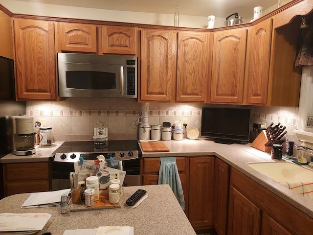 kitchen with stainless steel appliances, sink, and backsplash