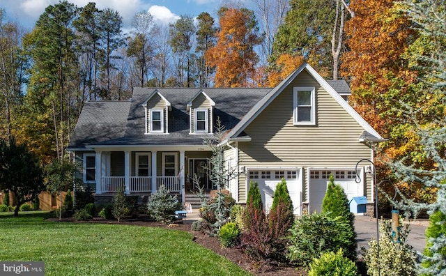 cape cod home with covered porch, a front yard, and a garage