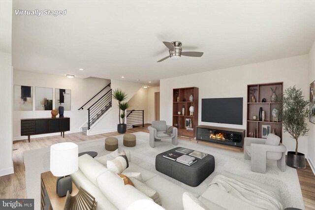 living room with ceiling fan and light wood-type flooring