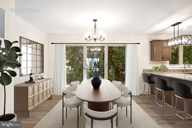 dining room with plenty of natural light, a notable chandelier, and dark hardwood / wood-style flooring