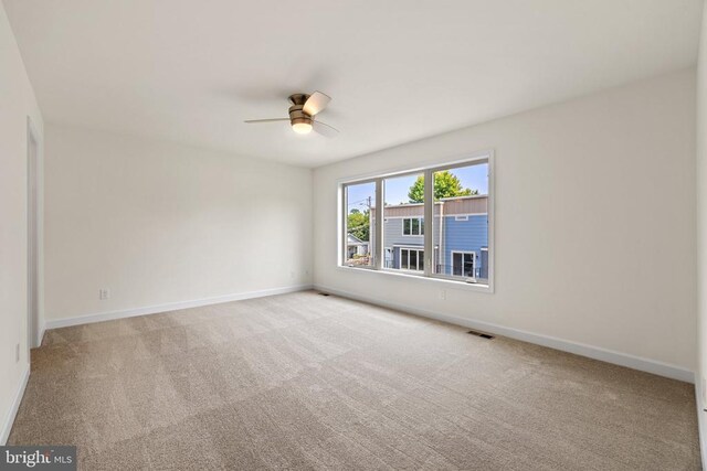 spare room with light colored carpet and ceiling fan