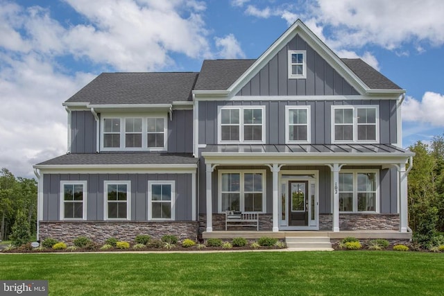 craftsman-style home featuring covered porch and a front yard