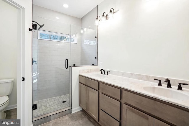 bathroom with tile patterned floors, vanity, toilet, and a shower with door