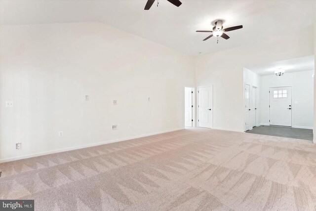 empty room with lofted ceiling, light colored carpet, and ceiling fan