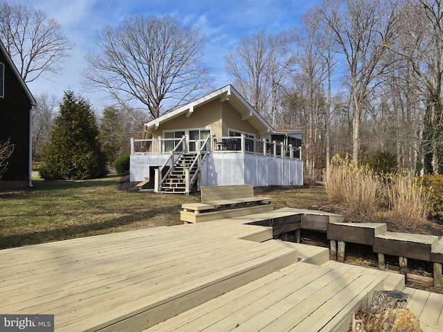 deck featuring stairs and a lawn