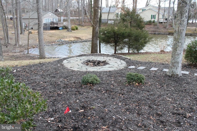 view of yard featuring a water view and a fire pit