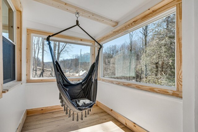 unfurnished sunroom featuring beam ceiling