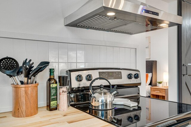 details with extractor fan and stainless steel range with electric cooktop