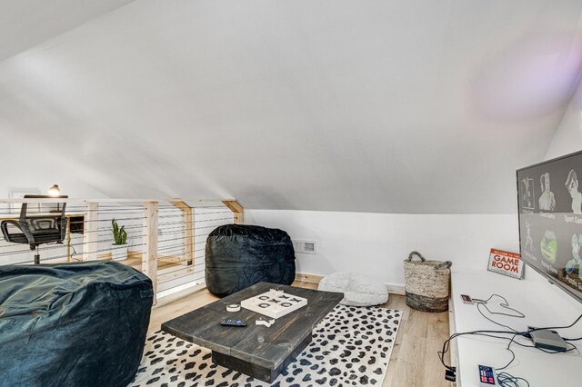 additional living space with lofted ceiling and light hardwood / wood-style floors