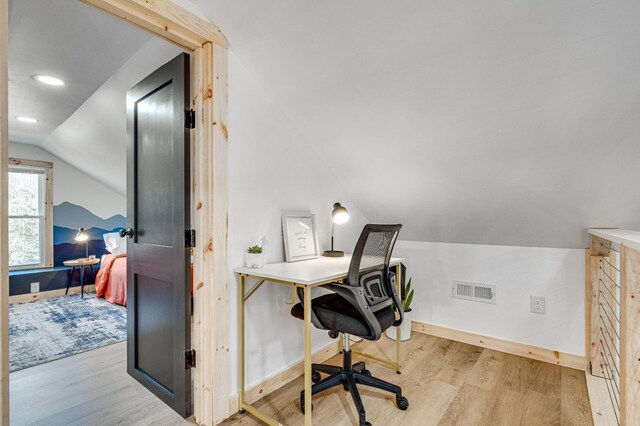 home office with lofted ceiling and light hardwood / wood-style flooring