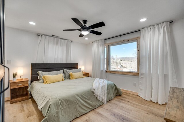 bedroom with ceiling fan and light hardwood / wood-style floors