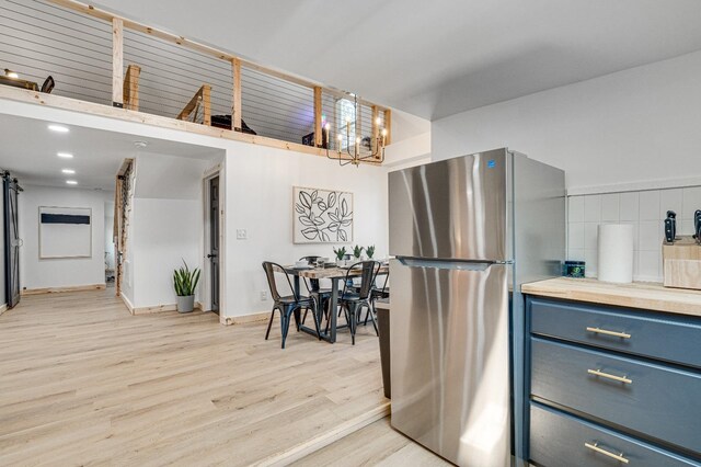 kitchen featuring a chandelier, stainless steel fridge, and light hardwood / wood-style floors