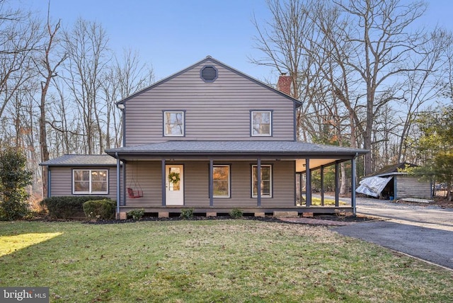 farmhouse-style home with driveway, a porch, roof with shingles, a front yard, and a chimney