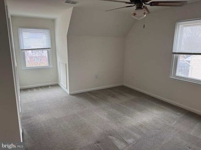 bonus room featuring lofted ceiling, a healthy amount of sunlight, light carpet, and ceiling fan