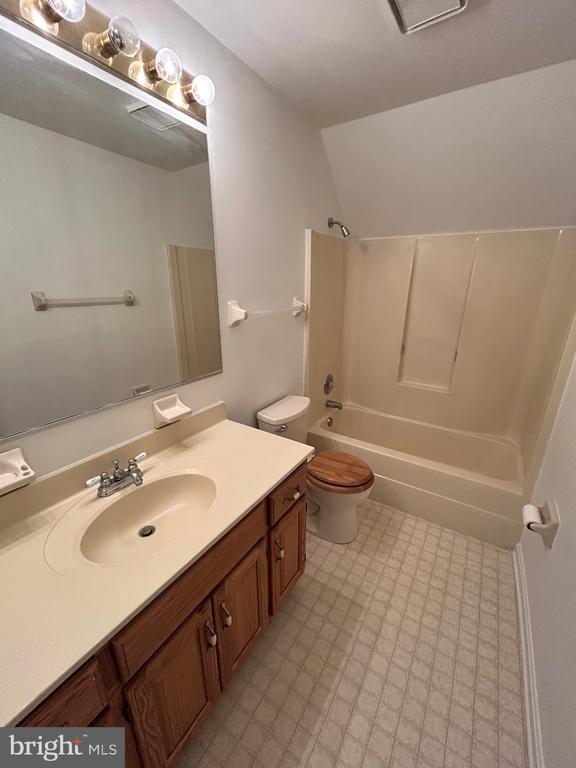 full bathroom featuring toilet, vanity, and bathtub / shower combination