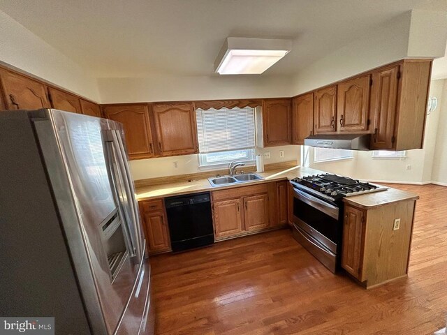 kitchen with appliances with stainless steel finishes, sink, and dark hardwood / wood-style flooring