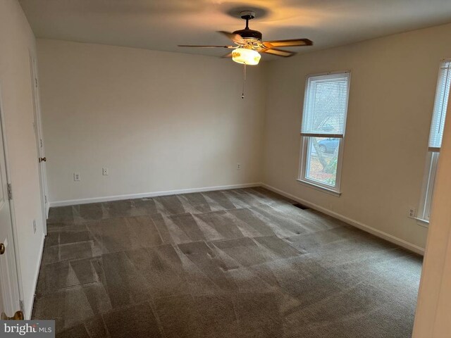 carpeted spare room featuring ceiling fan