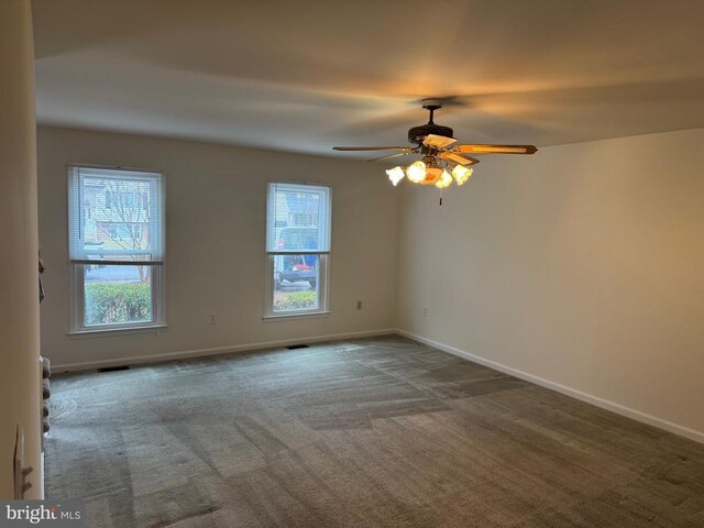 unfurnished room featuring ceiling fan and dark carpet