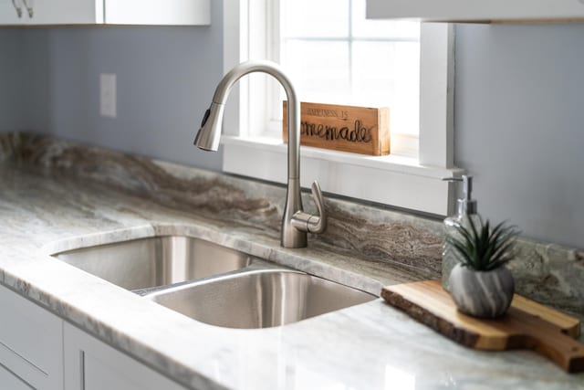 interior details featuring light countertops, a sink, and white cabinetry