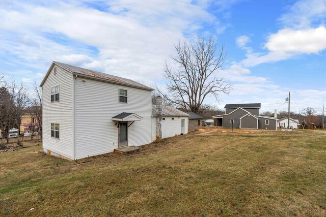 rear view of property featuring a yard