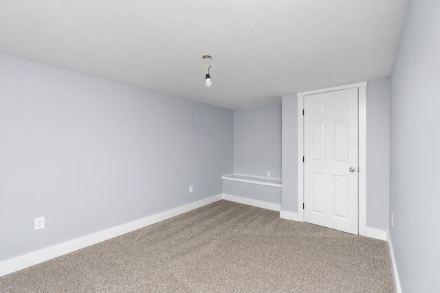 carpeted empty room with baseboards