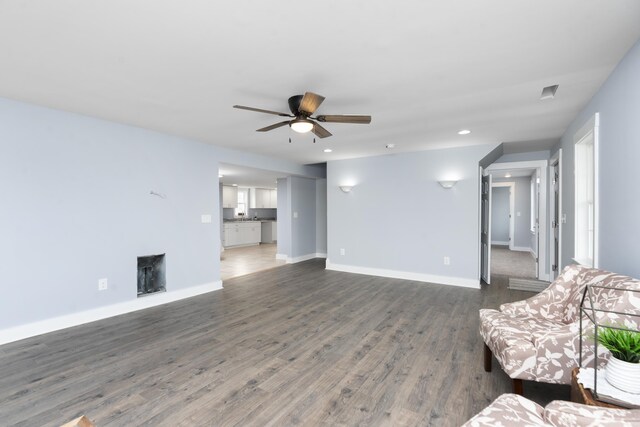 unfurnished living room featuring recessed lighting, wood finished floors, a ceiling fan, and baseboards