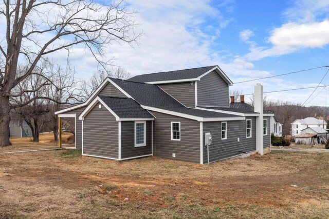 view of side of property with a shingled roof