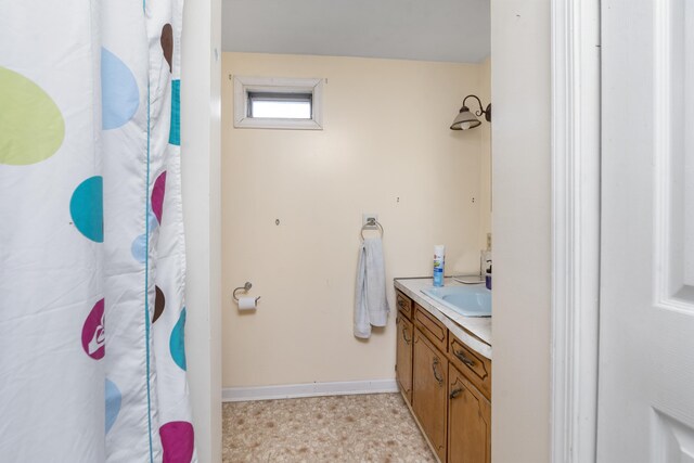 bathroom with tile patterned floors, baseboards, curtained shower, and vanity