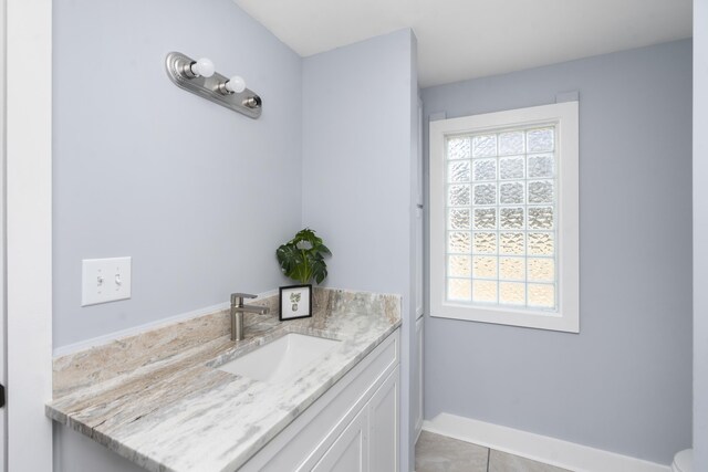 bathroom with plenty of natural light, vanity, and baseboards