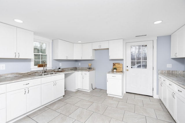 kitchen featuring white cabinets, a sink, and recessed lighting