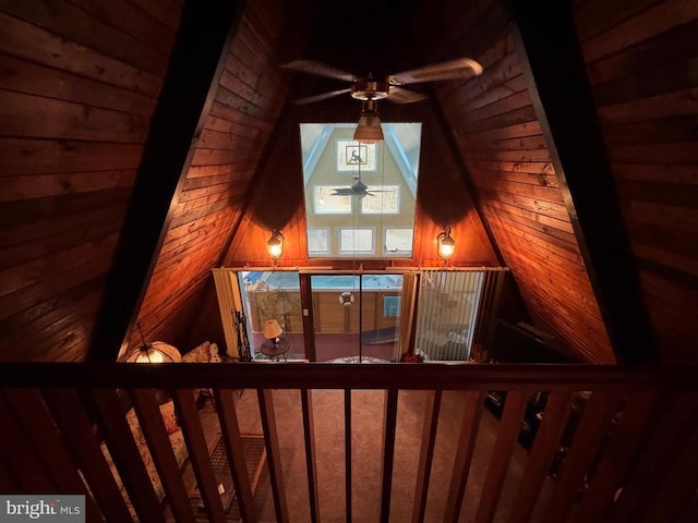 stairs with wooden walls and a ceiling fan