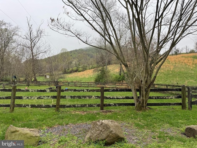 view of gate featuring a rural view and fence