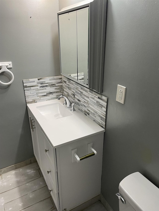 bathroom featuring tasteful backsplash, vanity, and toilet