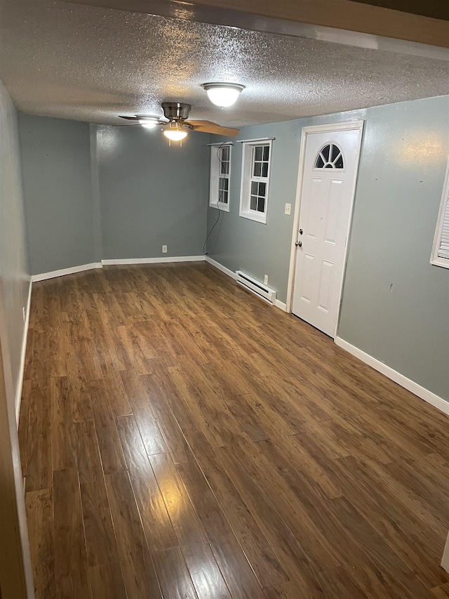 foyer entrance featuring baseboard heating, ceiling fan, dark hardwood / wood-style flooring, and a textured ceiling